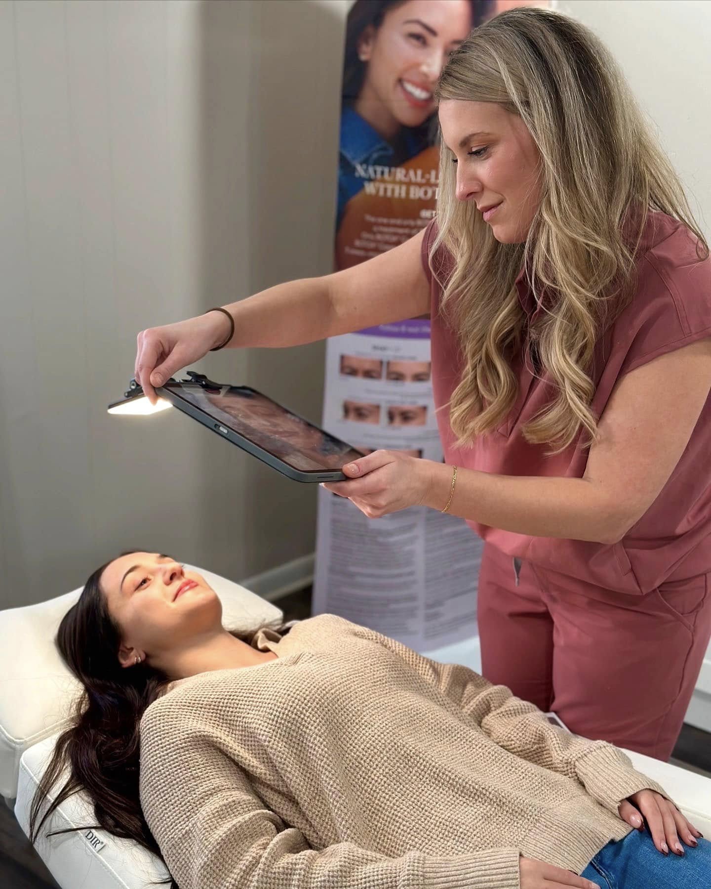 A provider showing a patient photos of her face on a tablet